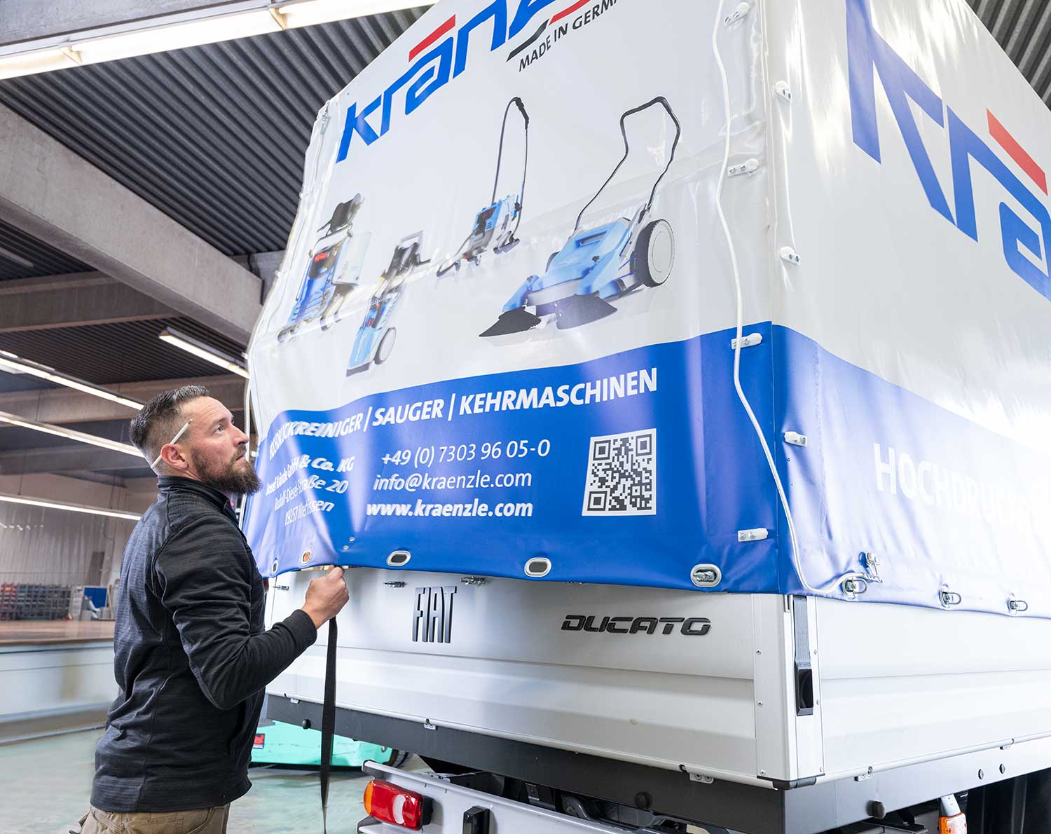 Montage von Planen an einem Kleintransporter in der Fertigung.