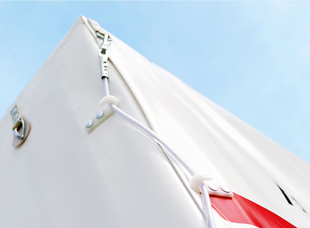 Planenbefestigung mit Ösen, Spannseil und Metallhalterung.